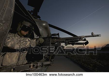 Picture - A UH-60L Blackhawk door gunner mans a M-240G machine gun.. Fotosearch