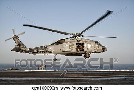 A US Navy SH-60F Seahawk hovers above the flight deck of USS Eisenhower. View Large Photo Image Picture - A US Navy SH-60F Seahawk hovers above the flight deck of USS Eisenhower.. Fotosearch