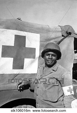 A World War II soldier stands next to his Red Cross vehicle. View Large Photo Image Picture - A World War II soldier stands next to his Red Cross vehicle.. Fotosearch