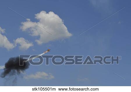 Picture - A Yakovlev Yak-55M aerobatic aircraft flys through a smoke ring.. Fotosearch