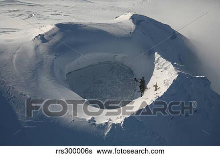 Stock Photograph - Aerial view of frozen lake in summit crater Mount Douglas volcano, Alaskan Peninsula.. Fotosearch