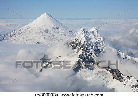 Stock Photograph - Aerial view of Shishaldin Volcano, with Isanotski Peaks in foreground, Alaska.. Fotosearch