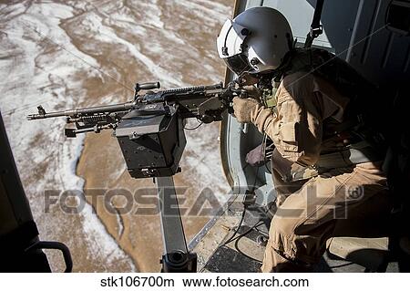 Picture - Afghan Air Force gunner fires an M-240 weapon from an Mi-17.. Fotosearch