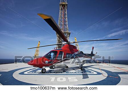 AgustaWestland AW109E utility helicopter on the helipad of an oil rig. View Large Photo Image Picture - AgustaWestland AW109E utility helicopter on the helipad of an oil rig.. Fotosearch