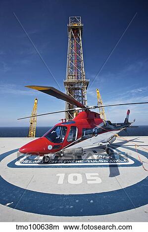 AgustaWestland AW109E utility helicopter on the helipad of an oil rig. View Large Photo Image Picture - AgustaWestland AW109E utility helicopter on the helipad of an oil rig.. Fotosearch
