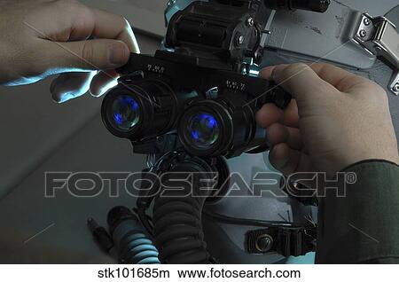 Airman adjusts the eyespan on a pair of night vision goggles. View Large Photo Image Picture - Airman adjusts the eyespan on a pair of night vision goggles.. Fotosearch