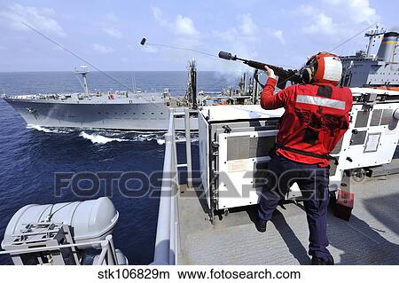 Airman fires a shot line from USS Bonhomme Richard. View Large Photo Image Picture - Airman fires a shot line from USS Bonhomme Richard.. Fotosearch