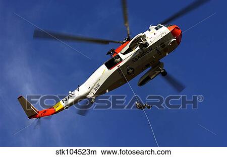 Picture - Airman practices rappelling out of a UH-3H helicopter.. Fotosearch