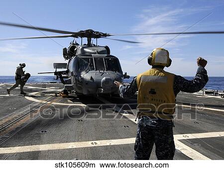 Airman signals to an MH-60S Sea Hawk helicopter aboard USS Momsen. View Large Photo Image Picture - Airman signals to an MH-60S Sea Hawk helicopter aboard USS Momsen.. Fotosearch