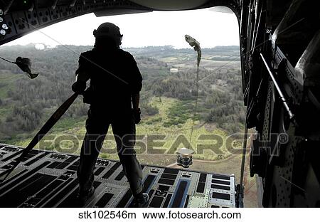 Airman watches a practice bundle fall from a C-17 Globemaster III. View Large Photo Image Picture - Airman watches a practice bundle fall from a C-17 Globemaster III.. Fotosearch
