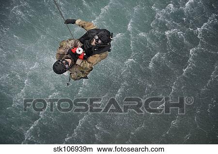 Airmen are hoisted out of the water during a water rescue training scenario. View Large Photo Image Picture - Airmen are hoisted out of the water during a water rescue training scenario.. Fotosearch