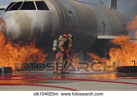 Picture - Airmen extinguish a fire on a training module to demonstrate an aircraft incident.. Fotosearch