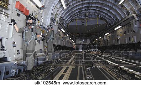 Airmen prepare to drop a practice bundle from a C-17 Globemaster III. View Large Photo Image Picture - Airmen prepare to drop a practice bundle from a C-17 Globemaster III.. Fotosearch