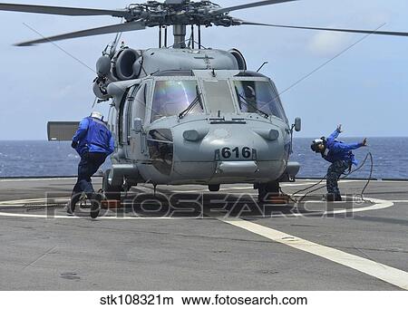 Airmen remove the chocks and chains from an MH-60S Sea Hawk. View Large Photo Image Picture - Airmen remove the chocks and chains from an MH-60S Sea Hawk.. Fotosearch
