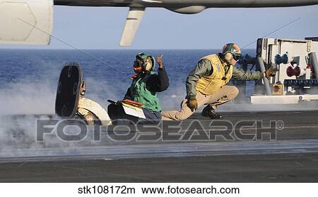 Airmen signal during a launch on the flight deck of USS Nimitz. View Large Photo Image Picture - Airmen signal during a launch on the flight deck of USS Nimitz.. Fotosearch