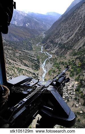 An aerial gunner surveys the surrounding area during a combat mission in Afghanistan. View Large Photo Image Picture - An aerial gunner surveys the surrounding area during a combat mission in Afghanistan.. Fotosearch