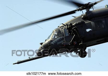 An aerial gunner waves goodbye from an HH-60G Pave Hawk. View Large Photo Image Picture - An aerial gunner waves goodbye from an HH-60G Pave Hawk.. Fotosearch