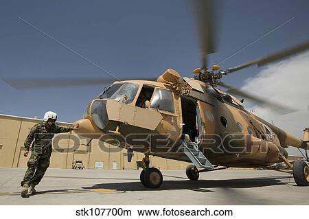 Picture - An Afghan Air Force aerial gunner makes final checks on a Mi-17 helicopter.. Fotosearch
