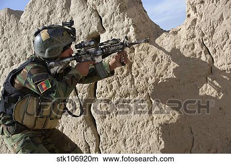 An Afghan Commando keeps watch for insurgents during a security operation. View Large Photo Image Picture - An Afghan Commando keeps watch for insurgents during a security operation.. Fotosearch