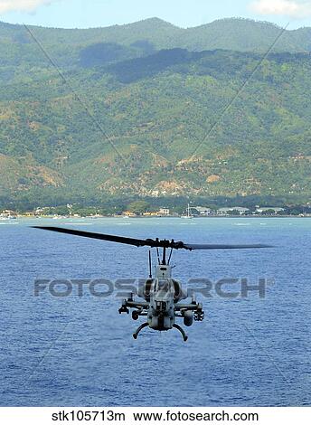 An AH-1W Super Cobra flies off the coast of Dili, East Timor. View Large Photo Image Picture - An AH-1W Super Cobra flies off the coast of Dili, East Timor.. Fotosearch