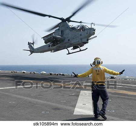 An AH-1Z Cobra helicopter takes off from the flight deck of USS Makin Island. View Large Photo Image Picture - An AH-1Z Cobra helicopter takes off from the flight deck of USS Makin Island.. Fotosearch