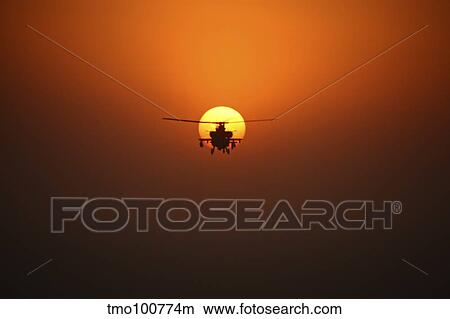 An AH-64D Apache helicopter flying into the sun over Iraq. View Large Photo Image Picture - An AH-64D Apache helicopter flying into the sun over Iraq.. Fotosearch