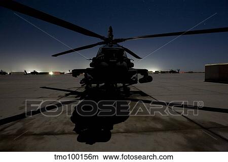 Picture - An AH-64D Apache Longbow Block III on the flight line at night.. Fotosearch