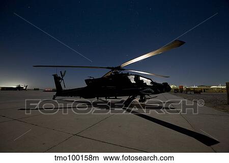Picture - An AH-64D Apache Longbow Block III on the flight line at night.. Fotosearch