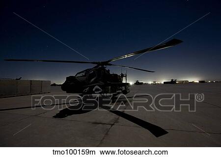 Picture - An AH-64D Apache Longbow Block III on the flight line at night.. Fotosearch