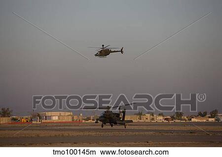 An AH-64D Apache Longbow Block III waits for an OH-58 Kiowa to clear his flight space. View Large Photo Image Picture - An AH-64D Apache Longbow Block III waits for an OH-58 Kiowa to clear his flight space.. Fotosearch