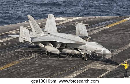 An aircraft director guides an F/A-18F Super Hornet aboard aircraft carrier USS Nimitz. View Large Photo Image Picture - An aircraft director guides an F/A-18F Super Hornet aboard aircraft carrier USS Nimitz.. Fotosearch