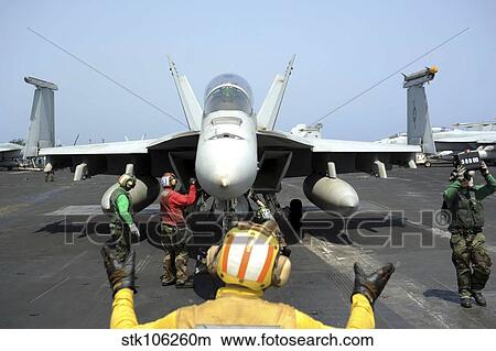 An aircraft director signals to the pilot of an F/A-18F Super Hornet. View Large Photo Image Picture - An aircraft director signals to the pilot of an F/A-18F Super Hornet.. Fotosearch