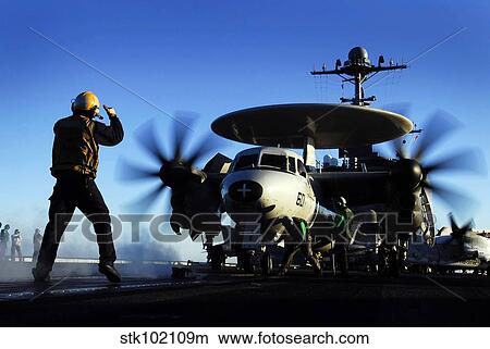 An Airman guides an E-2C Hawkeye. View Large Photo Image Picture - An Airman guides an E-2C Hawkeye.. Fotosearch