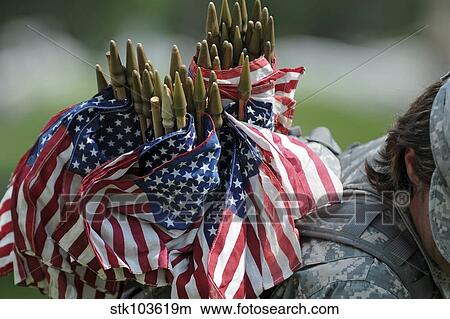 Picture - An Army soldier's backpack overflows with small American flags.. Fotosearch