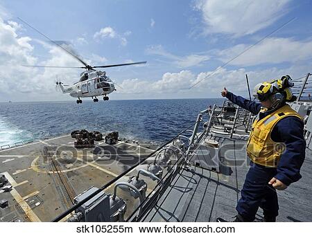 An AS-332 Super Puma helicopter during a vertical replenishment. View Large Photo Image Picture - An AS-332 Super Puma helicopter during a vertical replenishment.. Fotosearch
