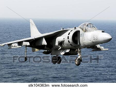 An AV-8B Harrier hovers over the flight deck of USS peleliu. View Large Photo Image Picture - An AV-8B Harrier hovers over the flight deck of USS peleliu.. Fotosearch