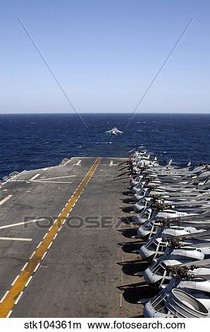 Picture - An AV-8B takes off from the flight deck of USS Tarawa lined with helicopters.. Fotosearch