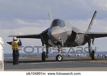 An aviation boatswain's mate directs an F-35B Lightning II aboard USS Wasp. View Large Photo Image Picture - An aviation boatswain's mate directs an F-35B Lightning II aboard USS Wasp.. Fotosearch