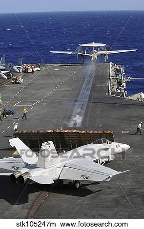 An E-2C Hawkeye launches from the flight deck of USS Abraham Lincoln. View Large Photo Image Picture - An E-2C Hawkeye launches from the flight deck of USS Abraham Lincoln.. Fotosearch