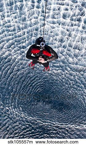Picture - An Explosive Ordnance Disposal Technician is hoisted to an MH-60S Sea Hawk.. Fotosearch