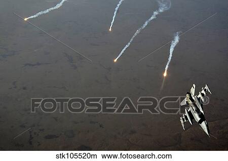 An F-16 Fighting Falcon jet pitches out while popping flares over Iraq. View Large Photo Image Picture - An F-16 Fighting Falcon jet pitches out while popping flares over Iraq.. Fotosearch