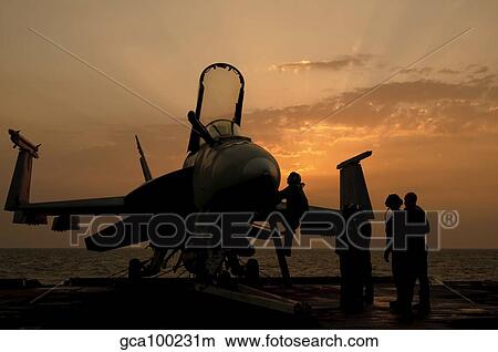 An F/18C Hornet aboard USS George H. W. Bush during sunrise. View Large Photo Image Picture - An F/18C Hornet aboard USS George H. W. Bush during sunrise.. Fotosearch
