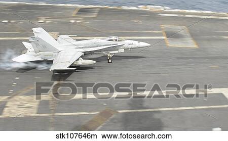 An F/A-18C Hornet lands on the flight deck of USS Nimitz. View Large Photo Image Picture - An F/A-18C Hornet lands on the flight deck of USS Nimitz.. Fotosearch