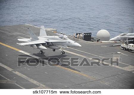 An F/A-18C Hornet lands on the flight deck of USS Nimitz. View Large Photo Image Picture - An F/A-18C Hornet lands on the flight deck of USS Nimitz.. Fotosearch