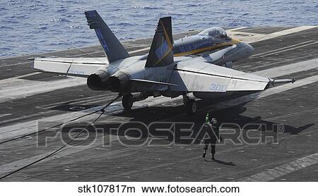 An F/A-18C Hornet lands on the flight deck of USS Nimitz. View Large Photo Image Picture - An F/A-18C Hornet lands on the flight deck of USS Nimitz.. Fotosearch