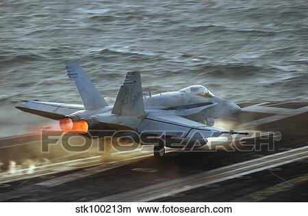 An F/A-18C Hornet launches from the flight deck of USS Theodore Roosevelt. View Large Photo Image Picture - An F/A-18C Hornet launches from the flight deck of USS Theodore Roosevelt.. Fotosearch