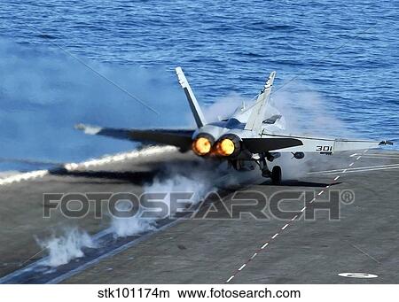 Picture - An F/A-18C Hornet launches from the flight deck aboard USS Abraham Linclon.. Fotosearch