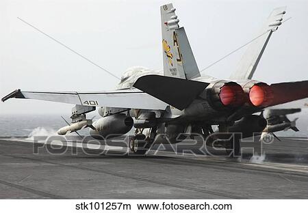 An F/A-18C Hornet launches from the flight deck of USS Theodore Roosevelt. View Large Photo Image Picture - An F/A-18C Hornet launches from the flight deck of USS Theodore Roosevelt.. Fotosearch