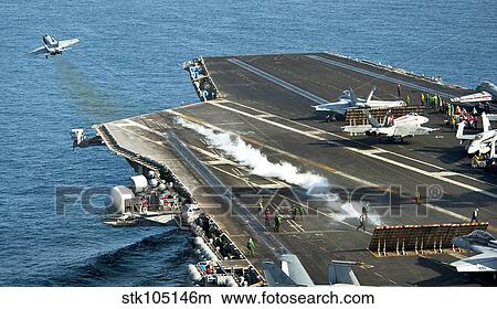 An F/A-18C Hornet launches from the flight deck of USS John C. Stennis. View Large Photo Image Picture - An F/A-18C Hornet launches from the flight deck of USS John C. Stennis.. Fotosearch