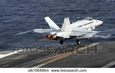 An F/A-18C Hornet launches from the flight deck of of USS Abraham Lincoln. View Large Photo Image Picture - An F/A-18C Hornet launches from the flight deck of of USS Abraham Lincoln.. Fotosearch